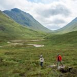 Dramatic Scottish Highlands landscape with rolling green hills and moody clouds