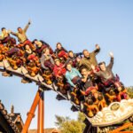 people with hands in the air on the pony express roller coaster