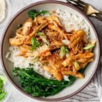 Crockpot honey garlic chicken served over white rice with broccolini in a bowl