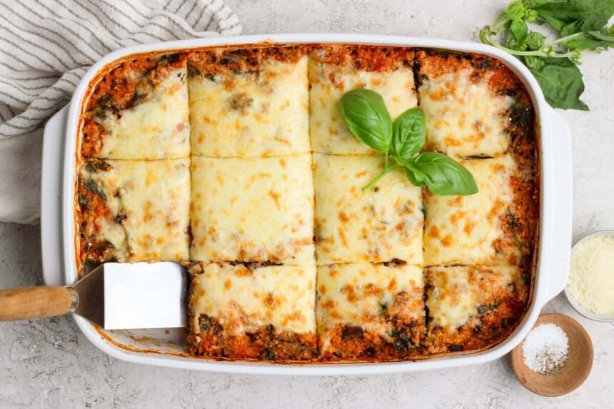 Overhead view of spinach quinoa lasagna casserole cut into squares in a baking dish