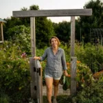 Woman standing at gate of garden in summer