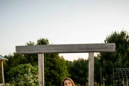 Woman standing at gate of garden in summer