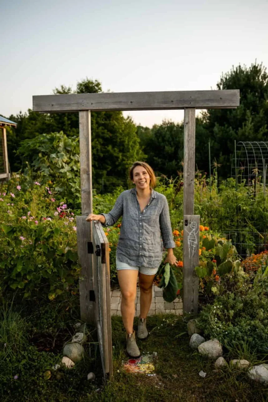 Woman standing at gate of garden in summer