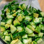 Simple avocado salad with cucumber, lime, and fresh cilantro in a bowl