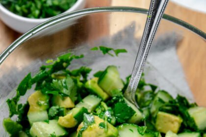 Simple avocado salad with cucumber, lime, and fresh cilantro in a bowl