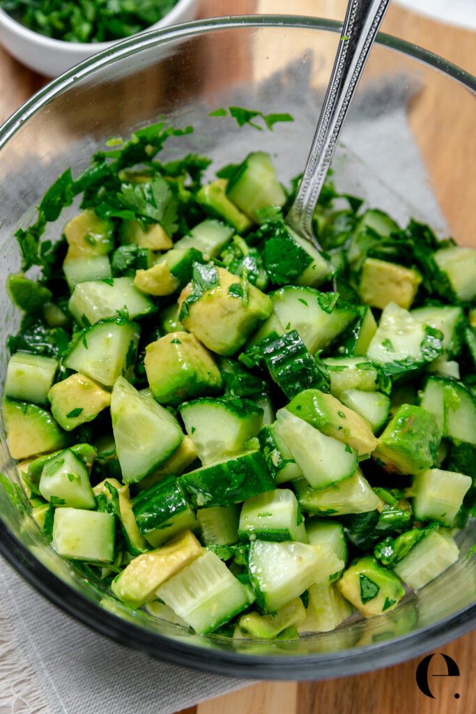Simple avocado salad with cucumber, lime, and fresh cilantro in a bowl