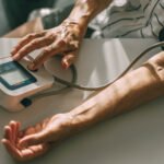 An elderly woman takes her blood pressure at home. Unrecognizable person, hand close-up.