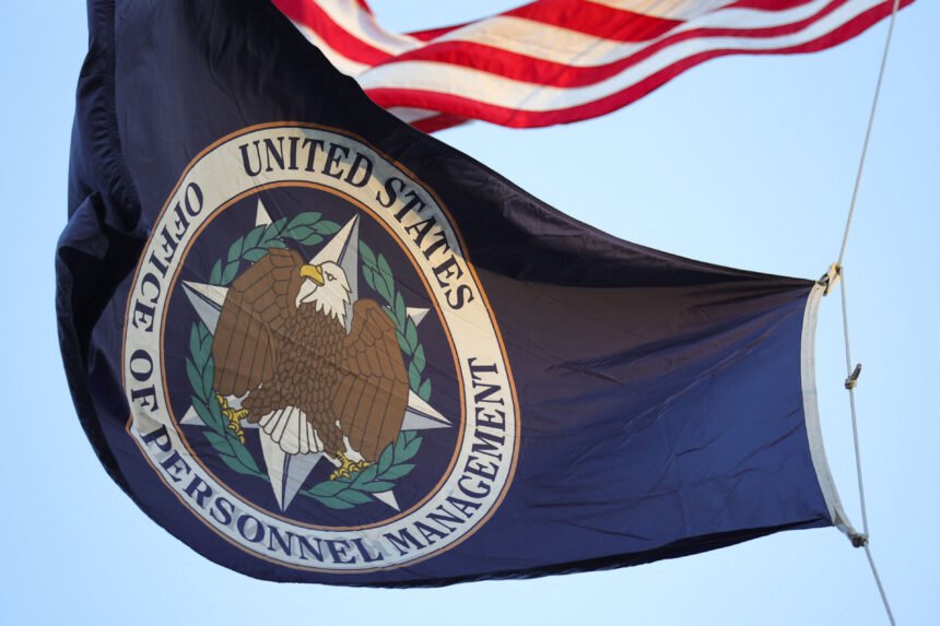 A flag with the seal of the Office of Personnel Management flies in the wind.