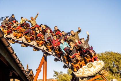 people with hands in the air on the pony express roller coaster