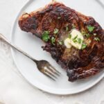 Sous vide steak with butter and fresh parsley on top.
