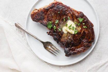 Sous vide steak with butter and fresh parsley on top.