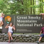 family posing in front of The Great Smoky Mountains National Par sign