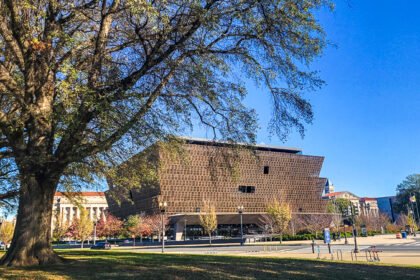 brown building of the national museum of african american history framed by tree