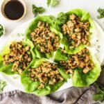 Chicken lettuce wraps on a serving platter with toppings.