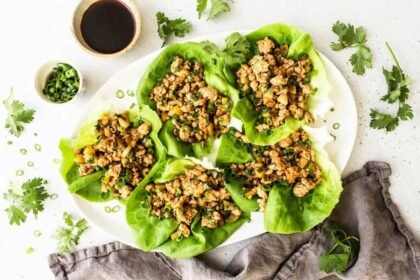 Chicken lettuce wraps on a serving platter with toppings.