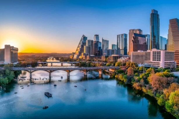 Austin, Texas- Cityscape with Colorado River in the middle against the sunset sky. There are boats near under the bridge at the front and a view of skycrapers on the side with reflective glass walls.